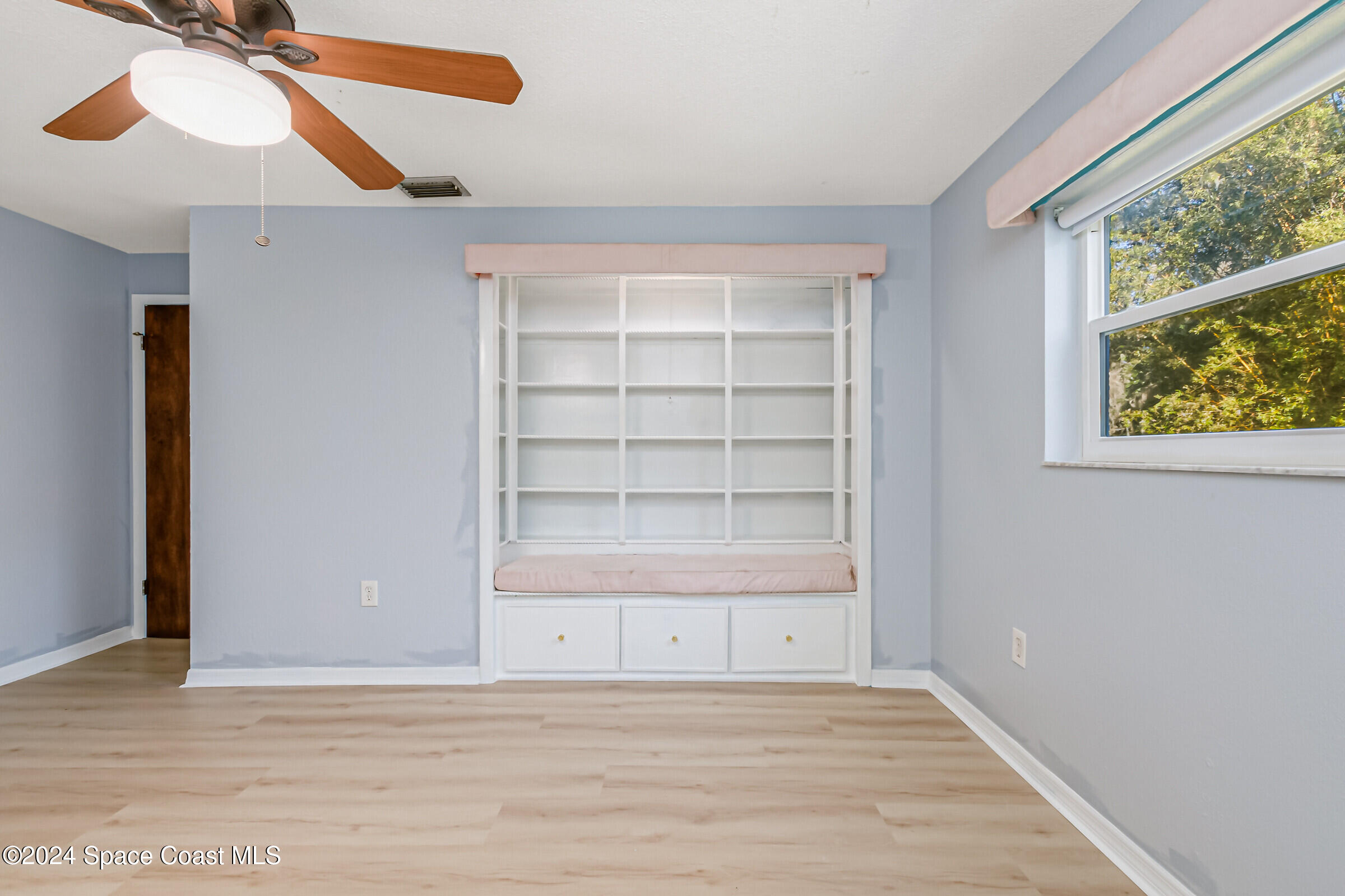 1235 Pine Island Road Merritt Island, FL 32953 - Photo 19 of 45 an empty room with wooden floor fan and windows