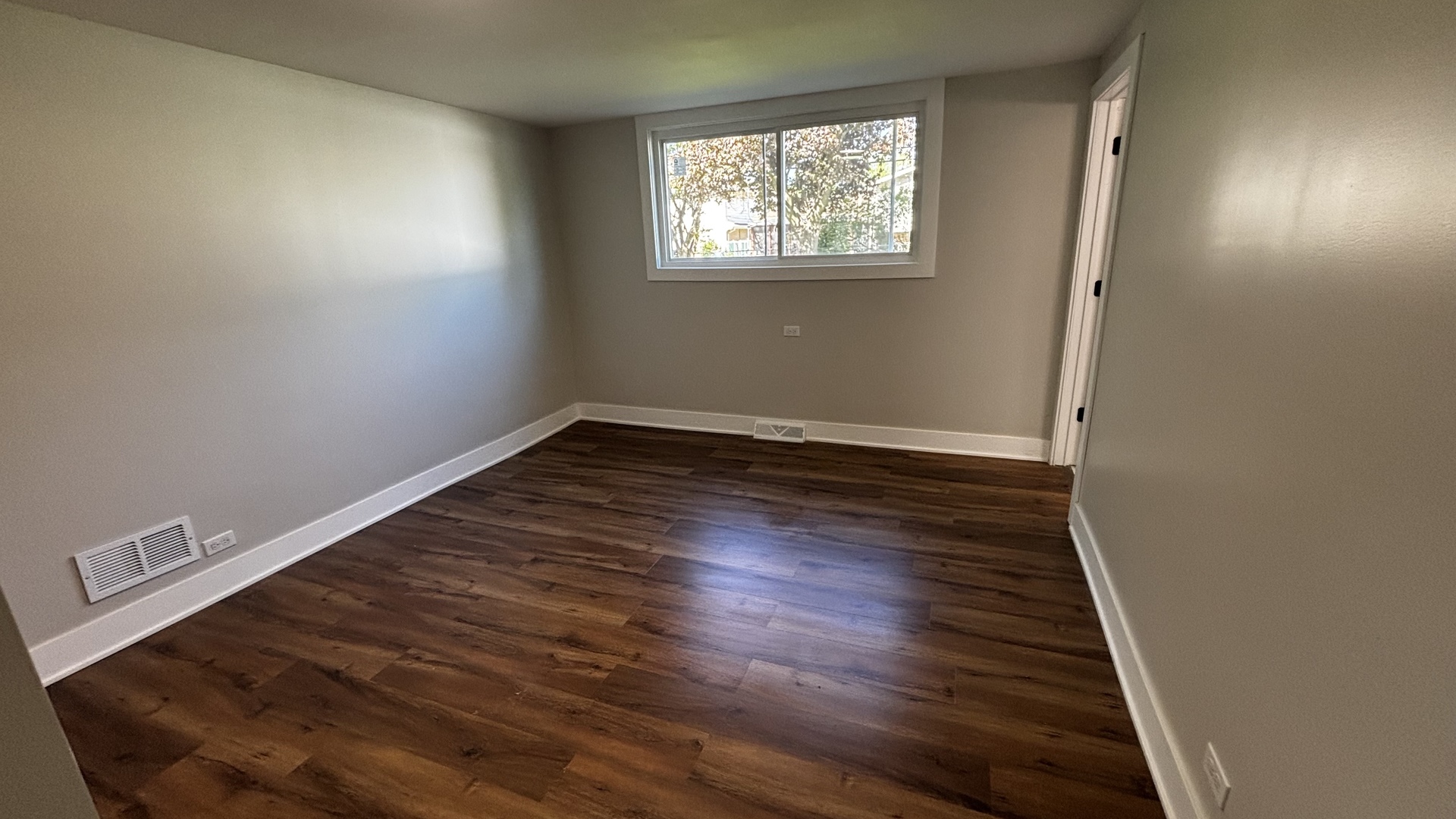 18314 Locust Street Lansing, IL 60438 - Photo 7 of 14 an empty room with wooden floor and windows