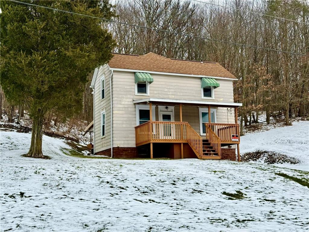 a front view of a house with a yard covered with snow