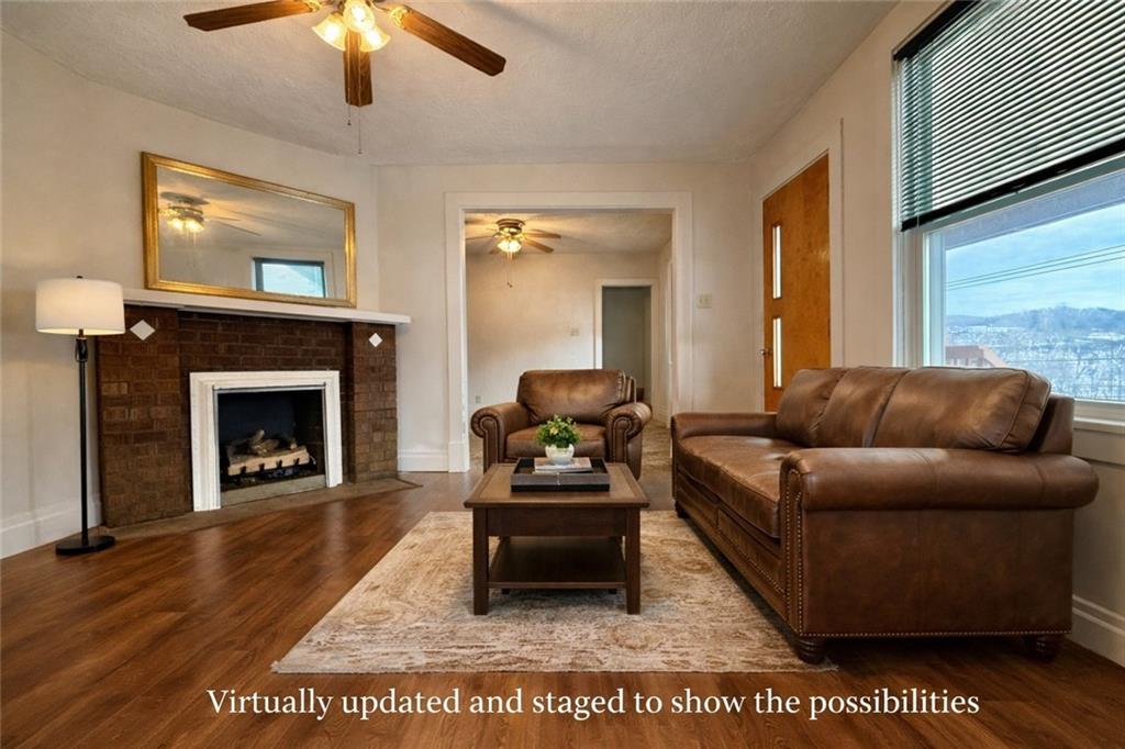 1126 Penn Avenue Vandergrift, PA 15690 - Photo 11 of 24 a living room with furniture a fireplace and a flat screen tv