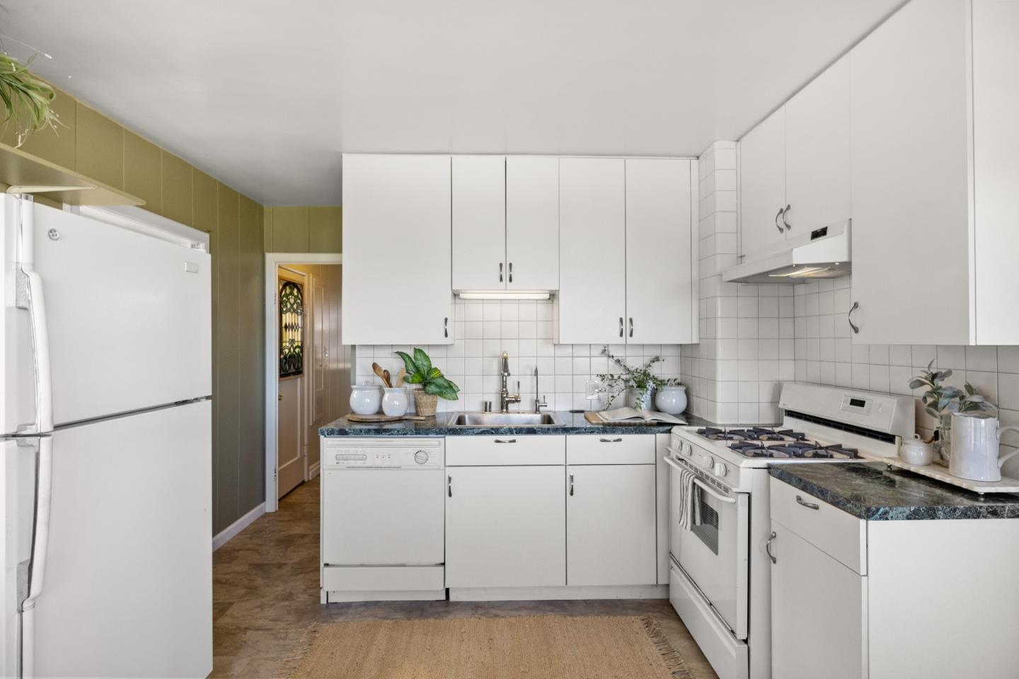 705 Grace Street Monterey, CA 93940 - Photo 6 of 28 a kitchen with a sink a stove a refrigerator and white cabinets