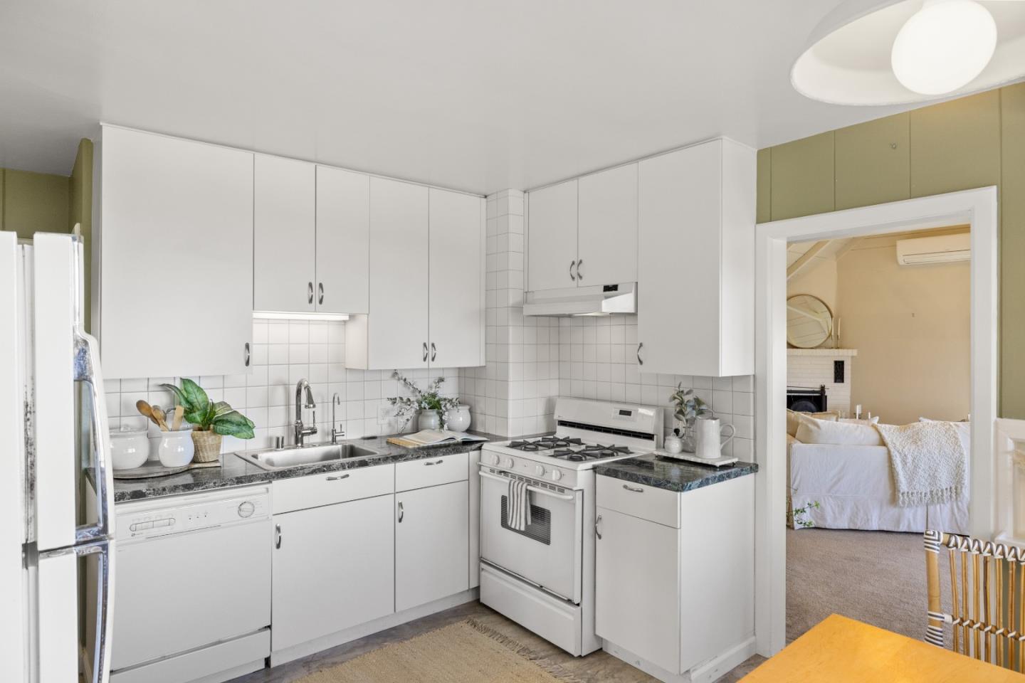 705 Grace Street Monterey, CA 93940 - Photo 7 of 28 a kitchen with granite countertop white cabinets and white appliances