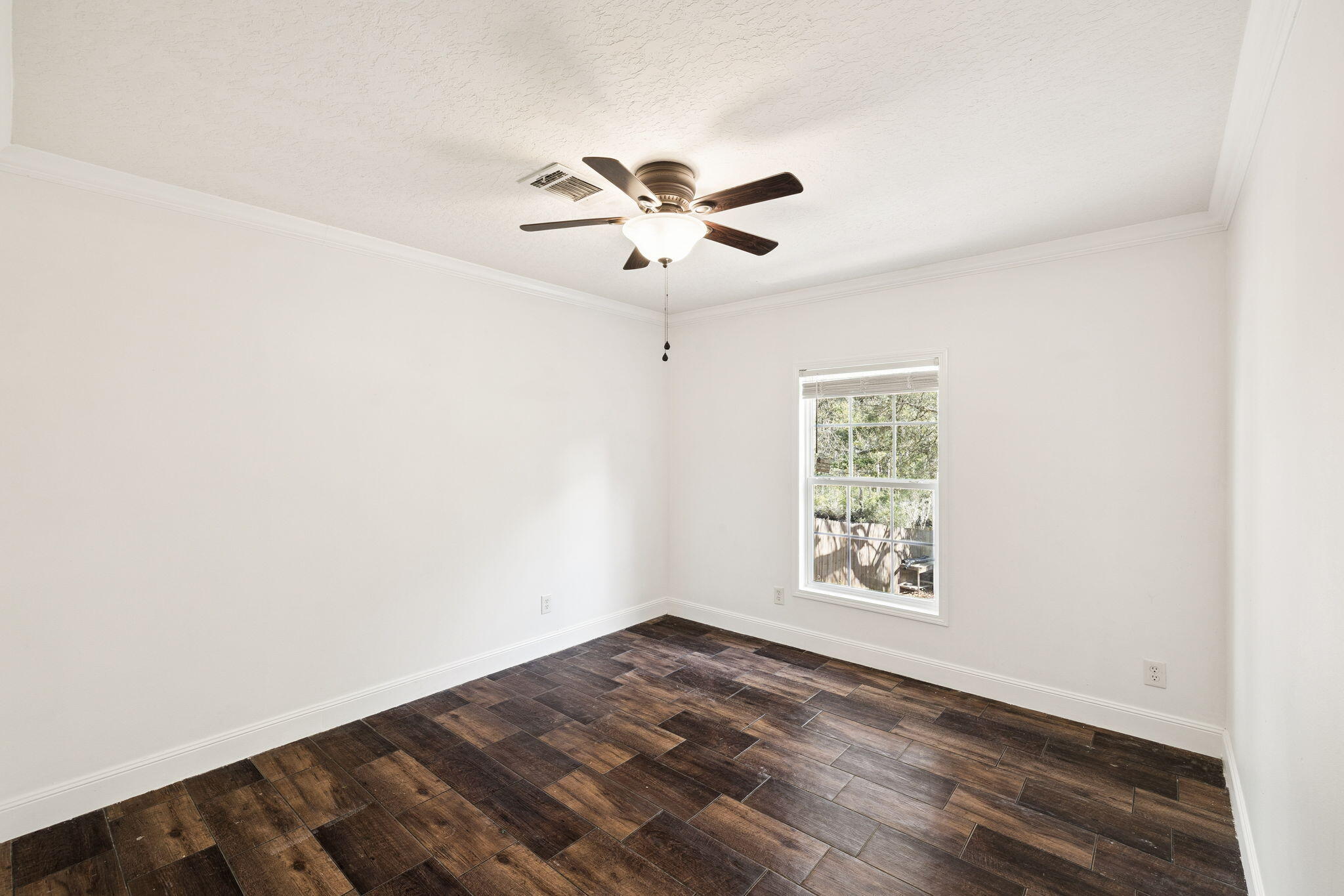 748 Phillips Drive Freeport, FL 32439 - Photo 24 of 32 an empty room with wooden floor ceiling fan and windows