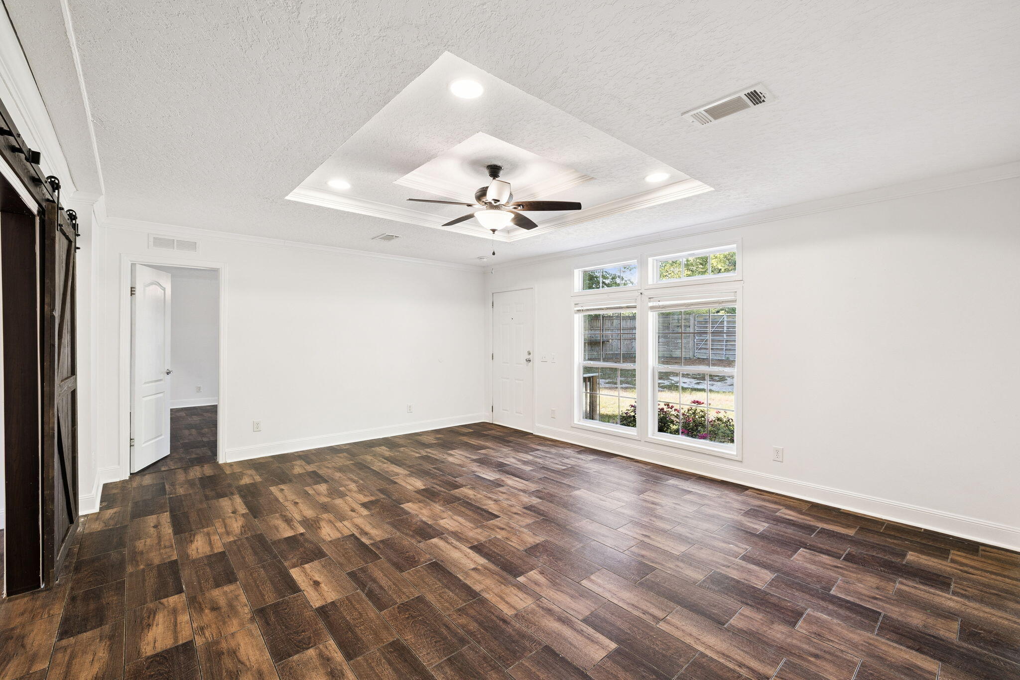 748 Phillips Drive Freeport, FL 32439 - Photo 7 of 32 a view of an empty room with a window and wooden floor
