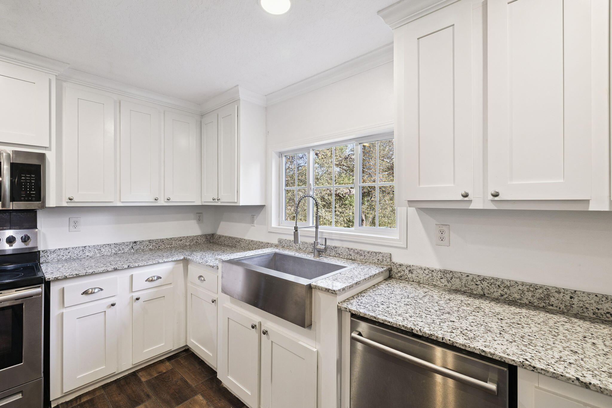 748 Phillips Drive Freeport, FL 32439 - Photo 10 of 32 a kitchen with granite countertop white cabinets and white appliances