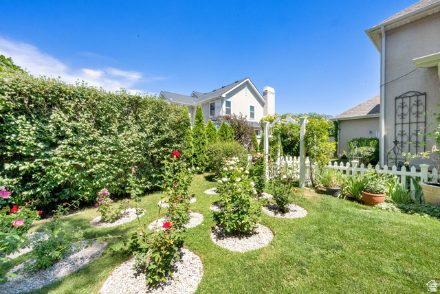 7740 Keswick Road Sandy, UT 84093 - Photo 61 of 74 Manicured lawn with a white picket fence and garden archways