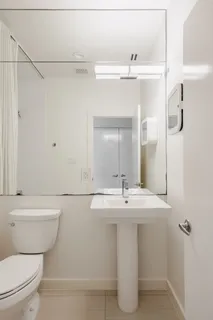 a bathroom with a sink a toilet a mirror and shower