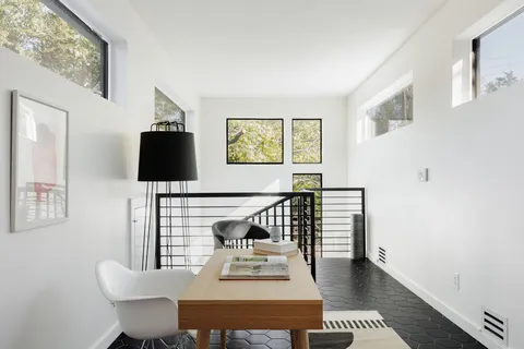 a view of a workspace room with furniture and window