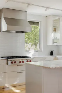 a kitchen with a stove and a white cabinet