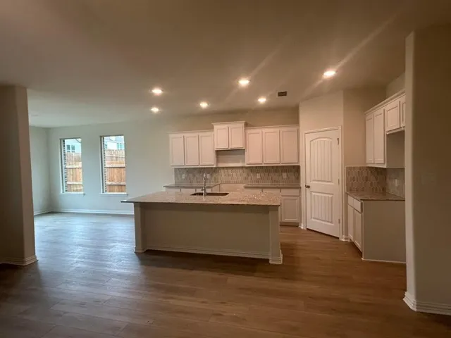 a large kitchen with stainless steel appliances granite countertop a stove a sink and a refrigerator