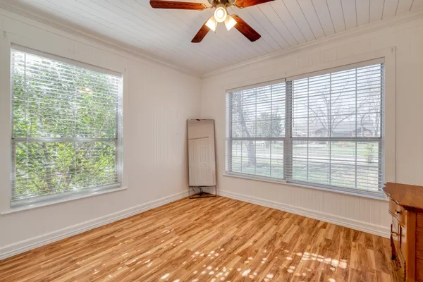 a view of empty room with wooden floor and window
