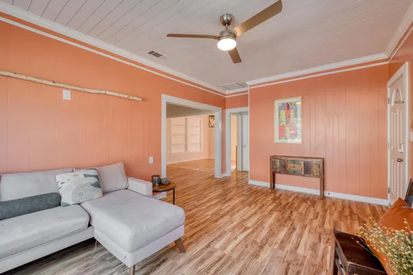 a living room with furniture and a wooden floor
