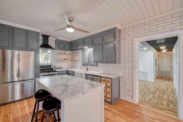 a kitchen with kitchen island a counter top space appliances and cabinets