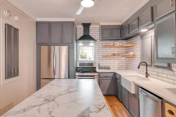 a kitchen with stainless steel appliances a sink stove and cabinets