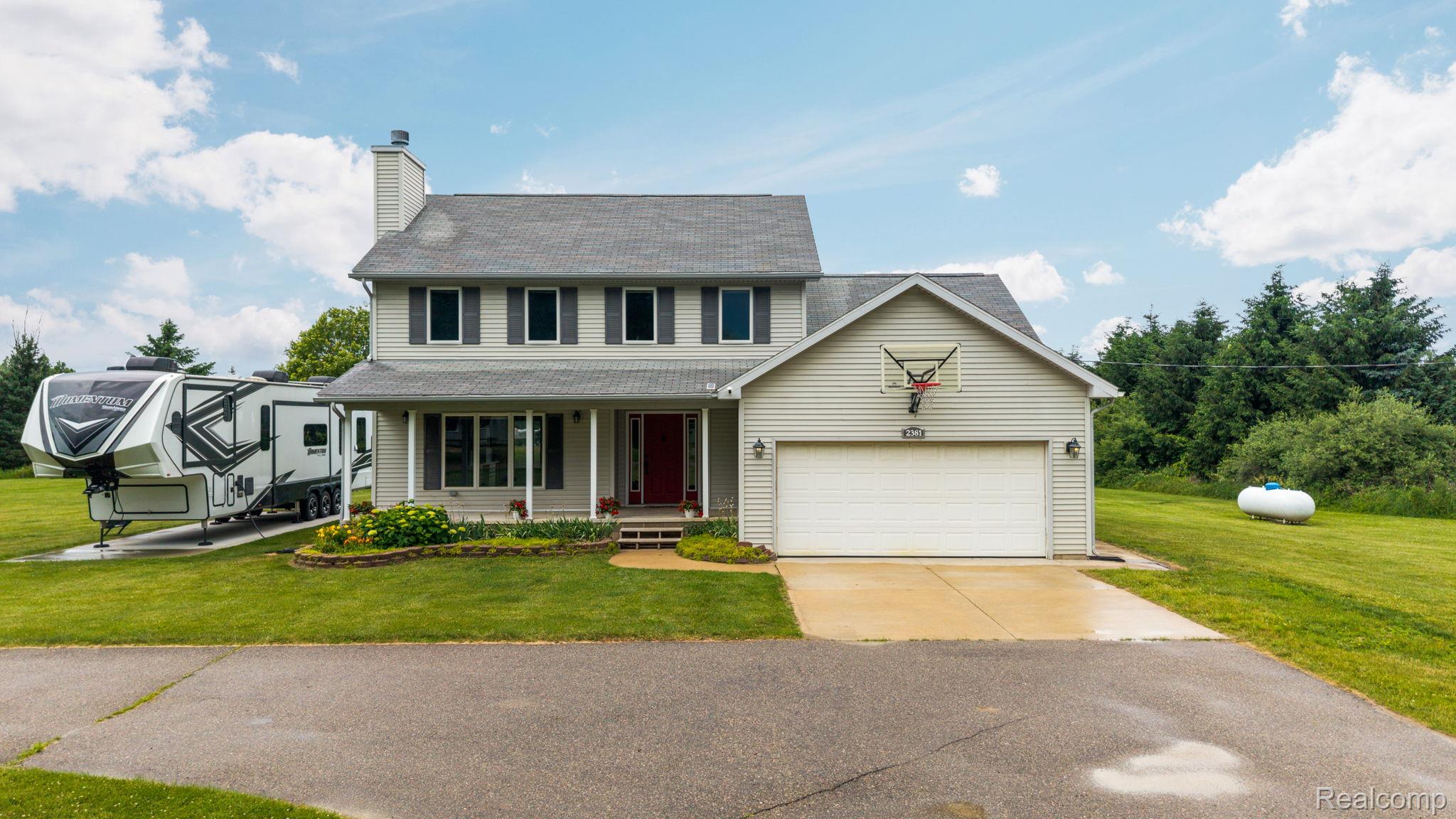 2381 Burke Road Fowlerville, MI 48836 - Photo 1 of 31 Two-story residence featuring light gray siding, dark shutters, and a covered front porch