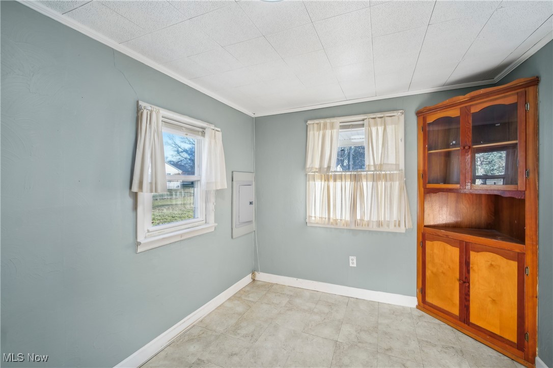 754 Fettro Road Akron, OH 44312 - Photo 8 of 31 Spare room featuring crown molding, plenty of natural light, and baseboards