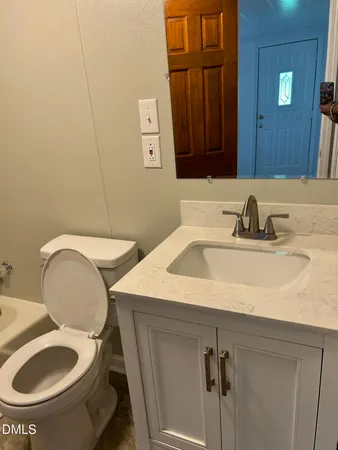 a bathroom with a toilet sink and mirror