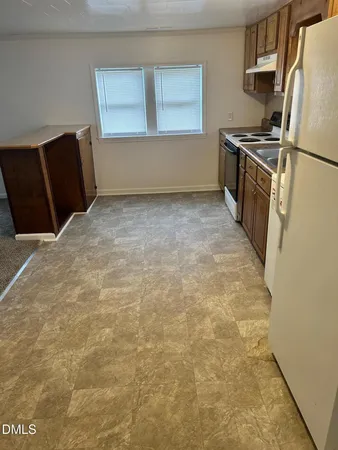 a kitchen with granite countertop a refrigerator and a stove top oven