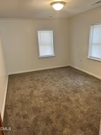 an empty room with a chandeliers fan