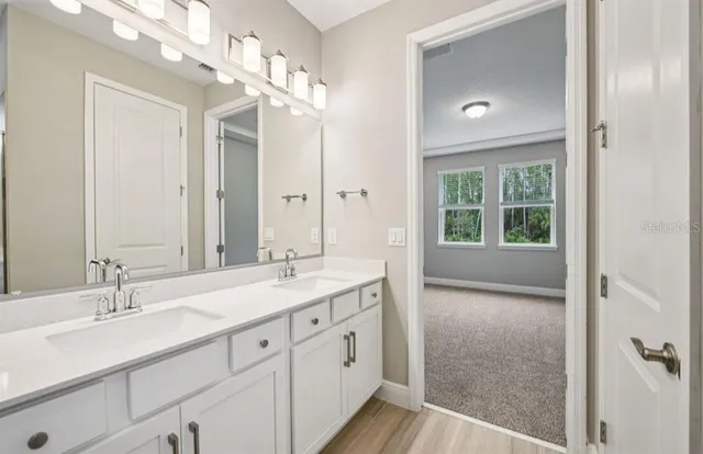 a spacious bathroom with a granite countertop sink a mirror and a shower