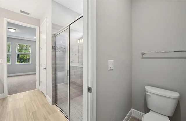 a bathroom with a toilet and a shower