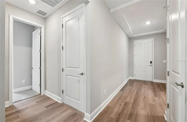 an empty room with wooden floor and entrance