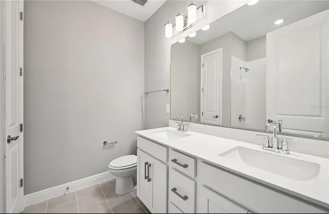 a bathroom with a granite countertop sink a toilet and a mirror