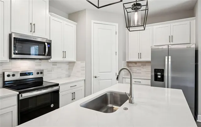 a kitchen with granite countertop a sink stainless steel appliances and cabinets