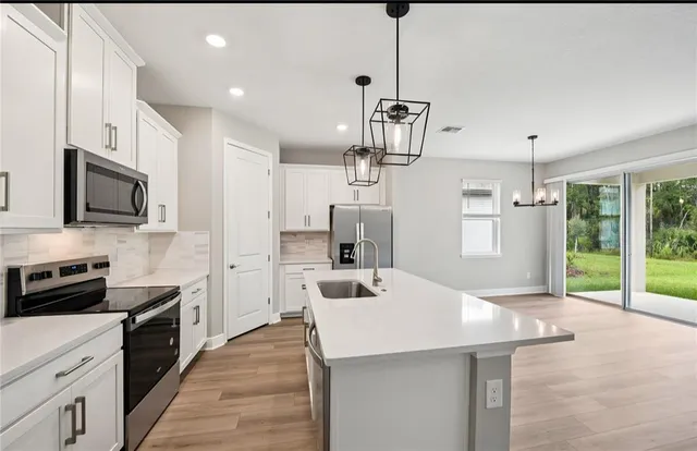 a kitchen with kitchen island a sink appliances and cabinets