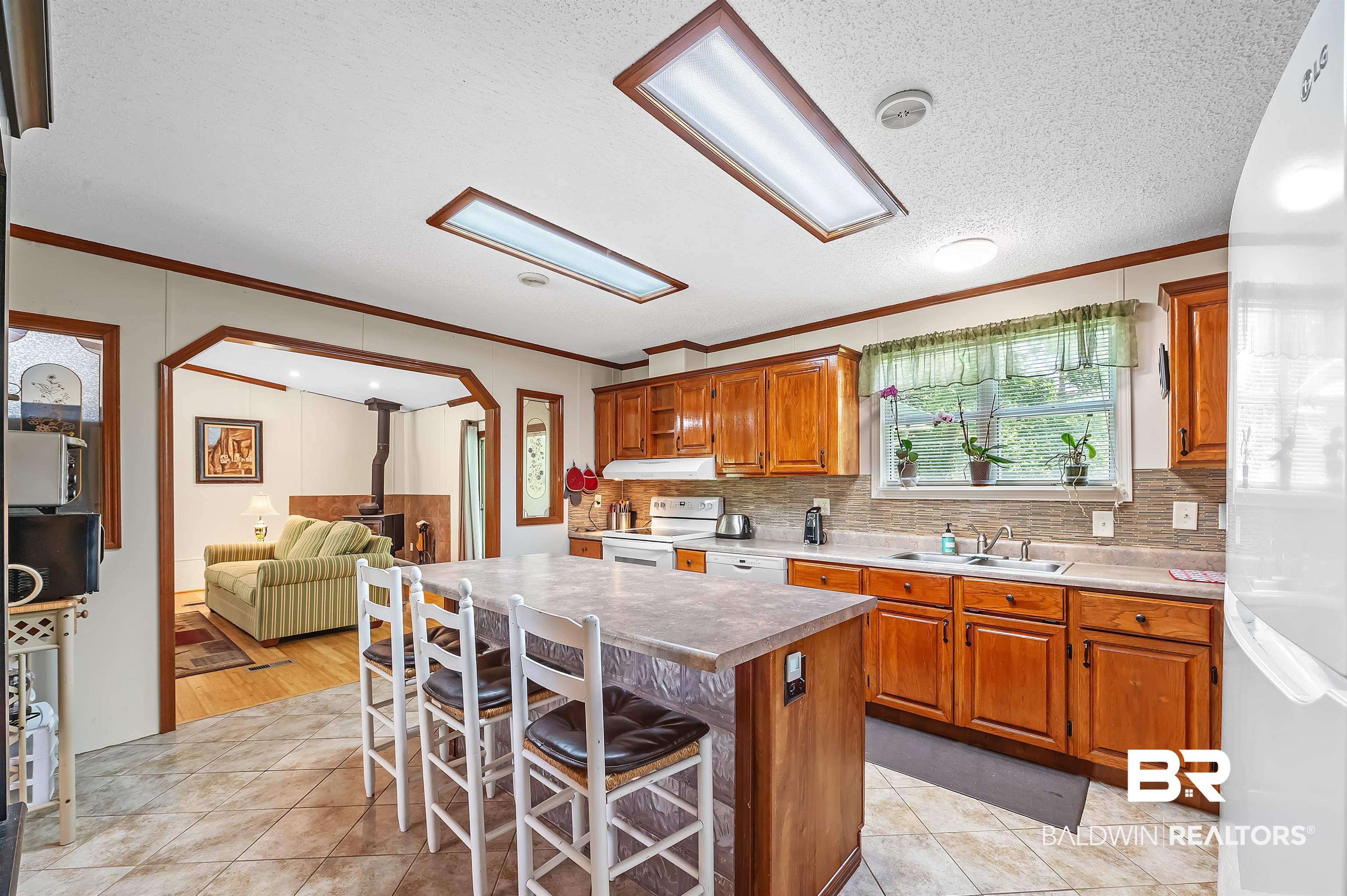 10970 Stucki Road Elberta, AL 36530 - Photo 23 of 56 Kitchen featuring light hardwood / wood-style flooring, white appliances, a kitchen island, a kitchen breakfast bar, and sink