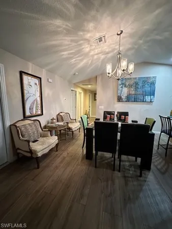 a living room with furniture kitchen view and a chandelier