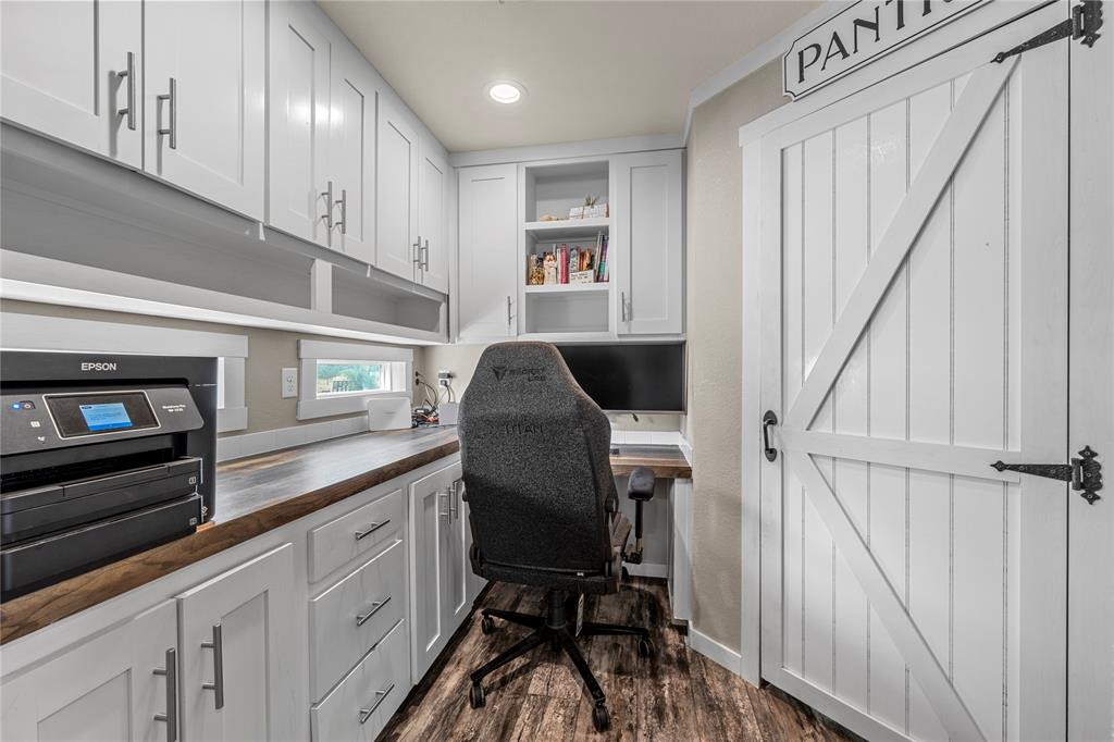 602 3rd Street Abbott, TX 76621 - Photo 27 of 40 Dedicated workspace featuring extensive white cabinetry, a wood-finish countertop, and wood-finish flooring