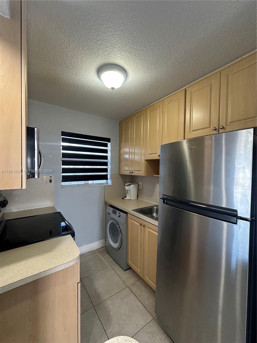 110 Southeast 2nd Street, Unit 312 Hallandale Beach, FL 33009 - Photo 7 of 7 a kitchen with a refrigerator sink and cabinets