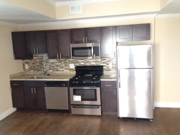 a kitchen with appliances a sink and a refrigerator