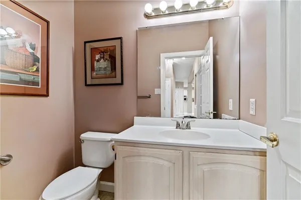 a bathroom with a toilet a sink and mirror