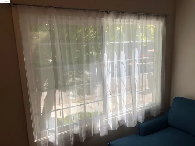 a living room with furniture and a floor to ceiling window