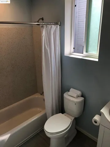 a white toilet sitting next to a bathtub