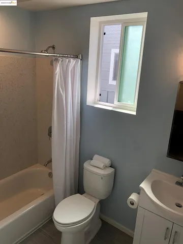 a white toilet sitting next to a bath tub