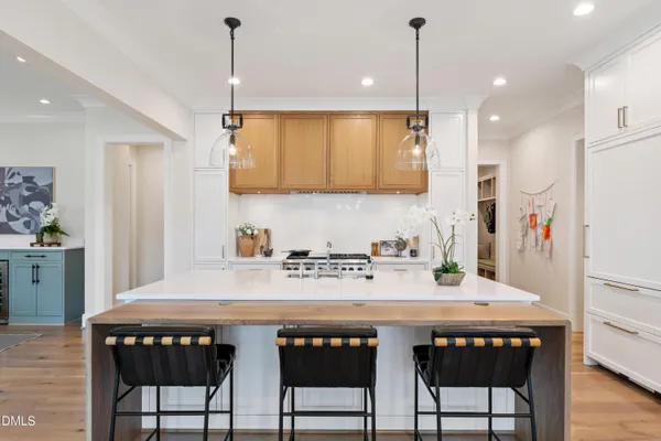 a large dining hall with stainless steel appliances granite countertop a stove a sink a dining table and chairs with wooden floor