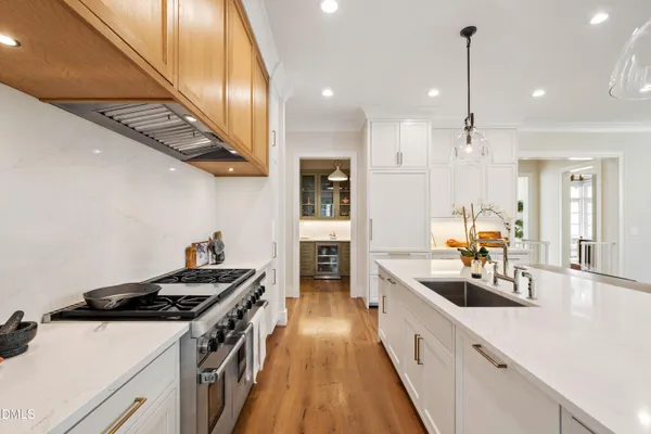 a large white kitchen with a large island in the center