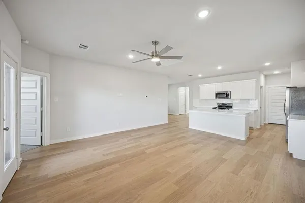 an empty room with wooden floor and windows