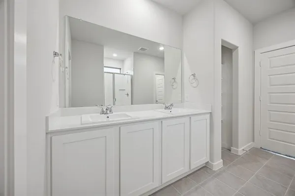 a bathroom with double sink and a mirror