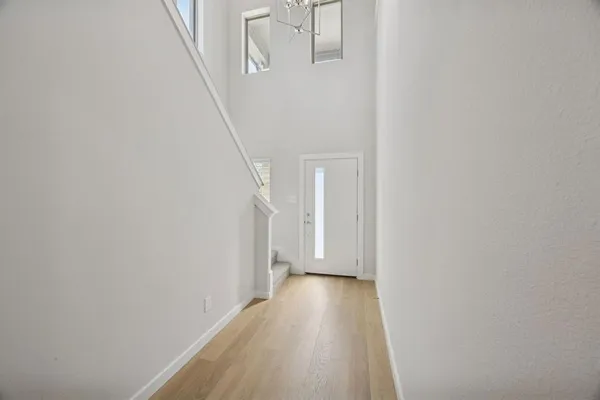 a view of a hallway with wooden floor and entryway