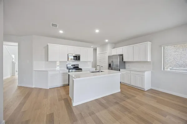 a kitchen with white cabinets and white appliances