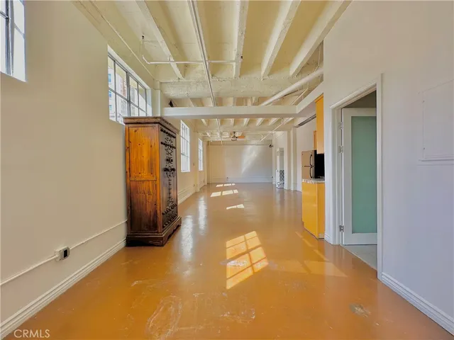a view of kitchen with stainless steel appliances wooden floor and chair