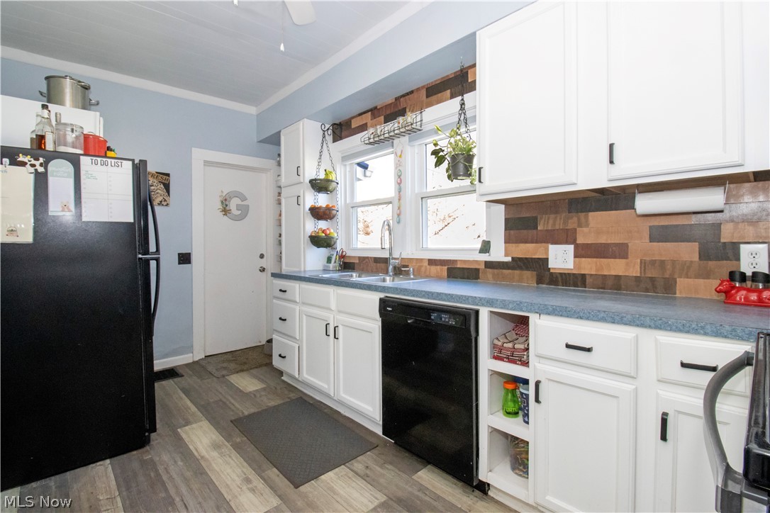 5299 Overton Road Wooster, OH 44691 - Photo 17 of 26 Kitchen with black appliances, sink, dark hardwood / wood-style floors, backsplash, and white cabinets