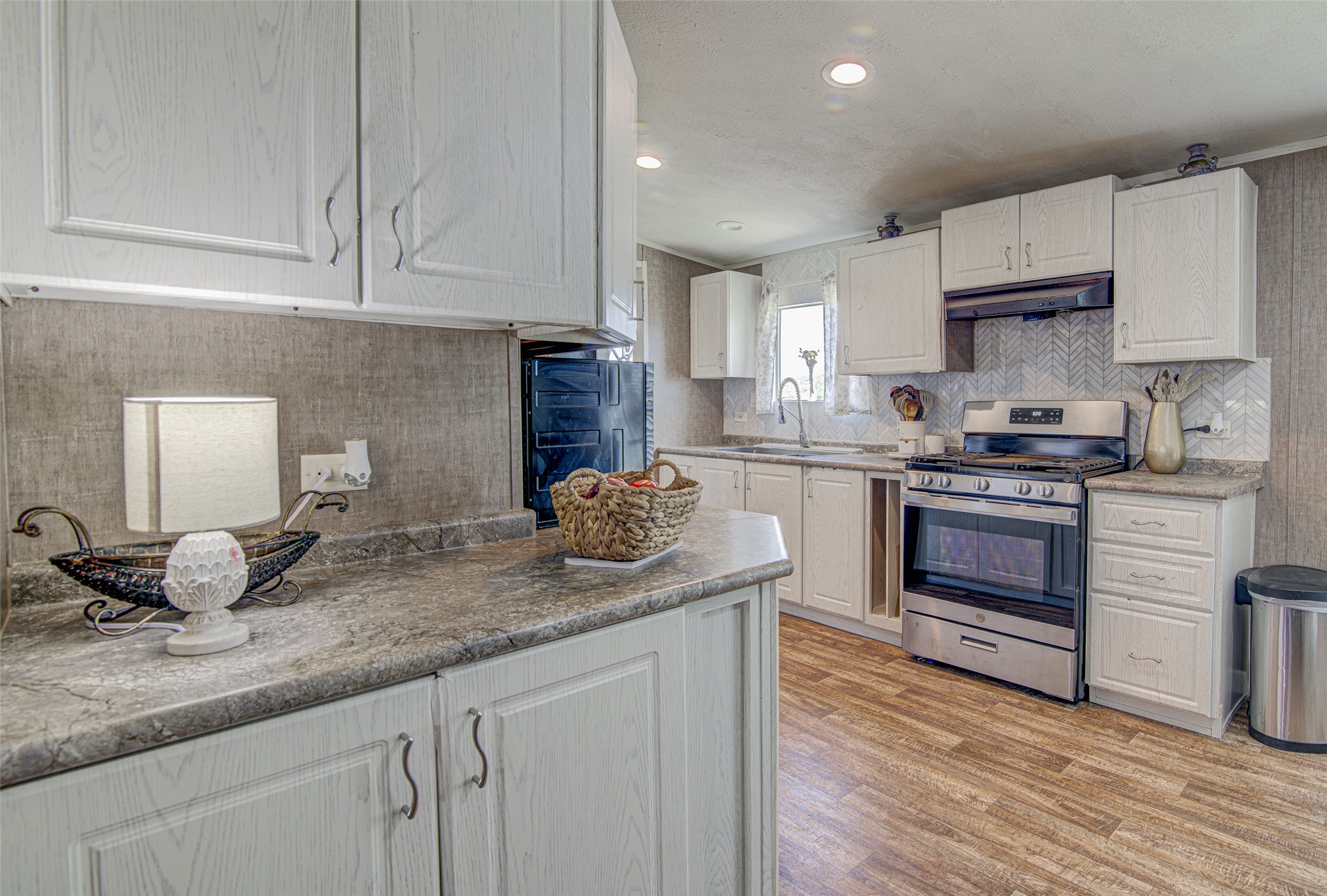 445 Rancho Linda Drive Lockhart, TX 78644 - Photo 14 of 26 Well-equipped kitchen boasting sleek appliances, ample cabinetry, and rich wood-toned flooring.