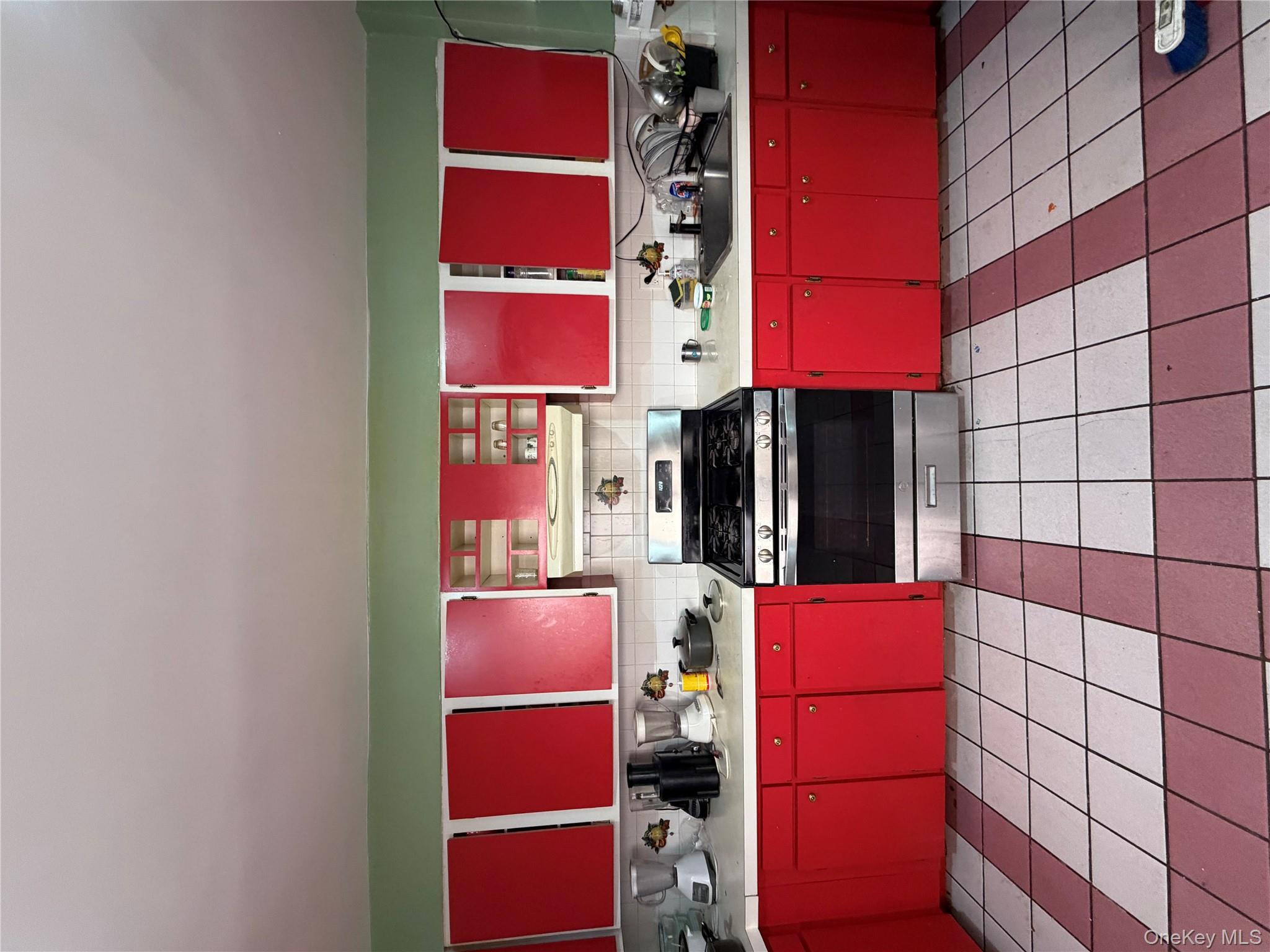 35-13 103rd Street Queens, NY 11368 - Photo 5 of 13 a kitchen with stainless steel appliances a stove a sink and a red stove