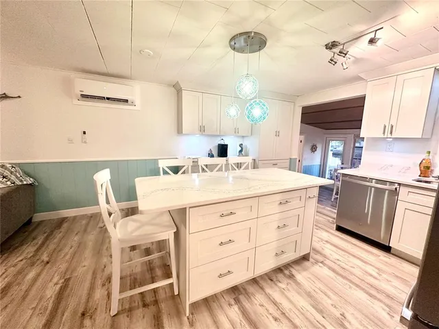 a kitchen with a stove a sink a dining table and chairs with wooden floor
