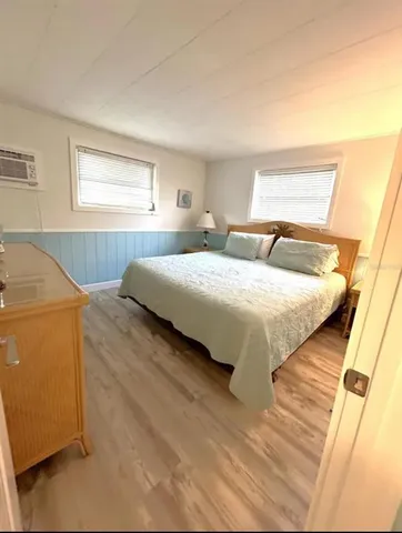 a bedroom with a bed and a dresser next to a window